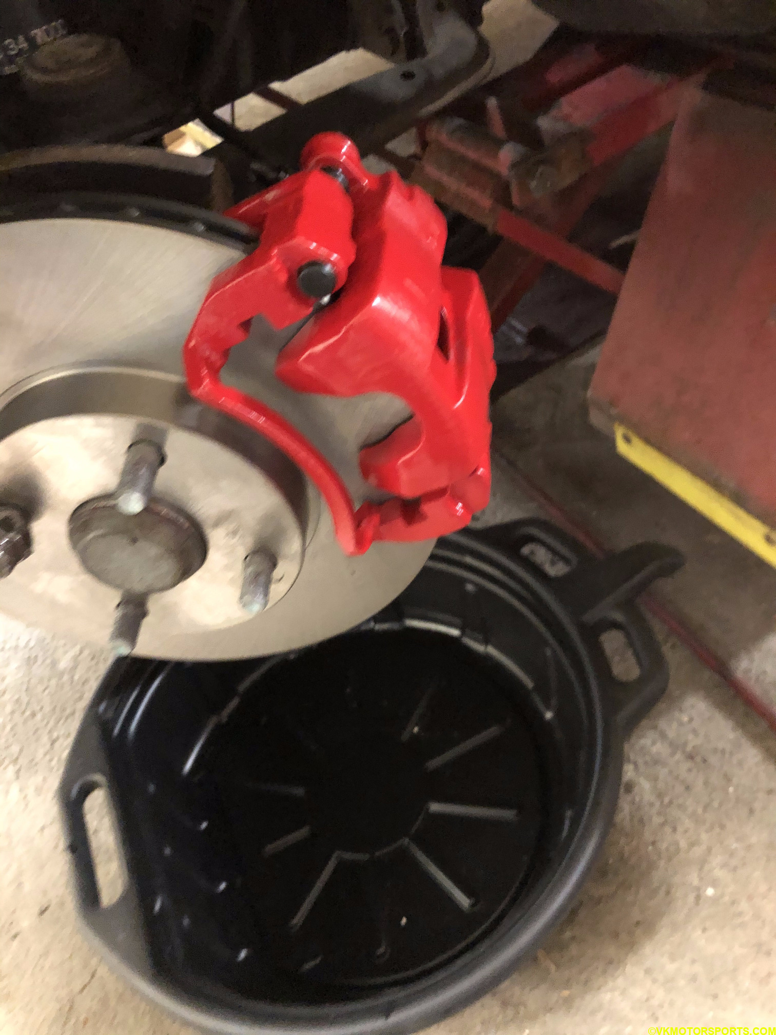 Place container below rotor to catch overflowing brake fluid