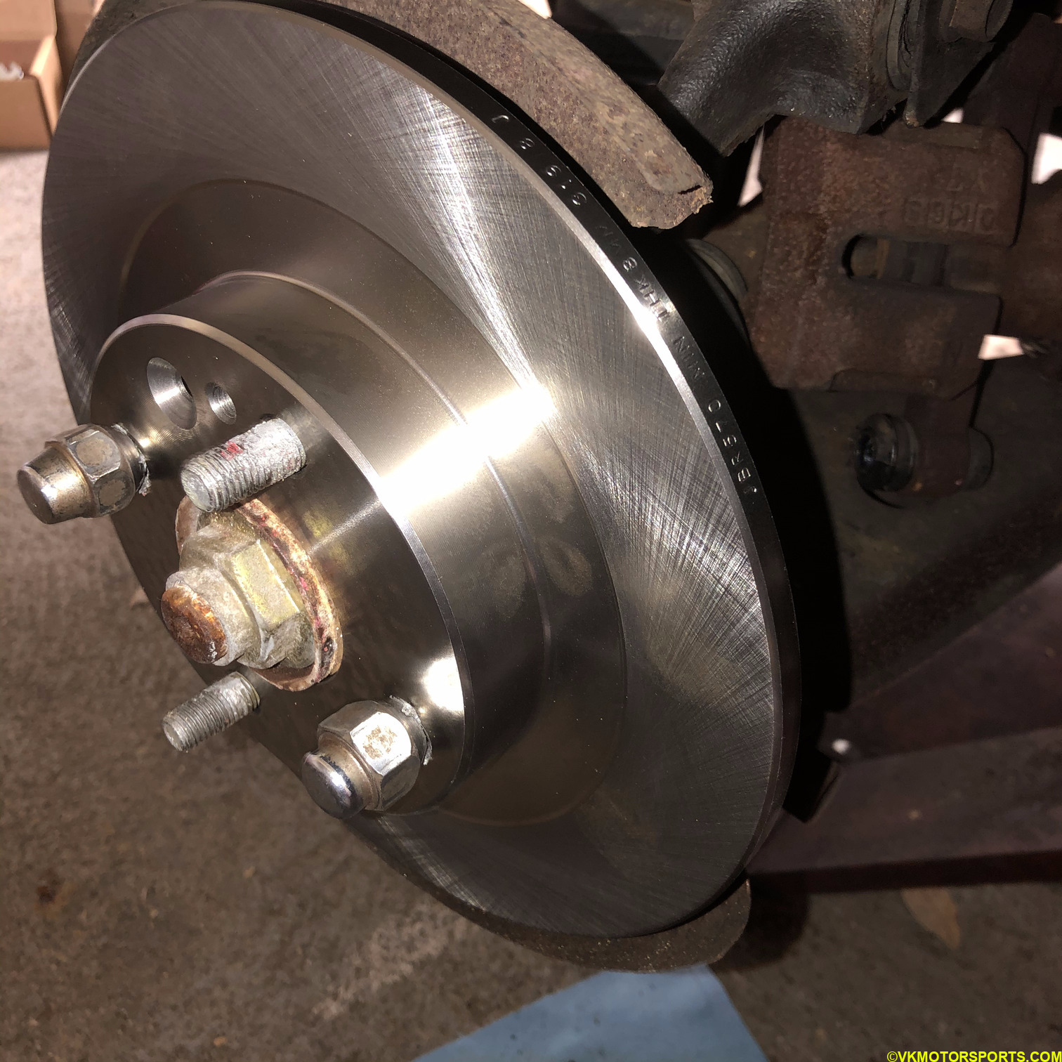 Place new rotor on the wheel hub and hold it in place with 2 lug nuts