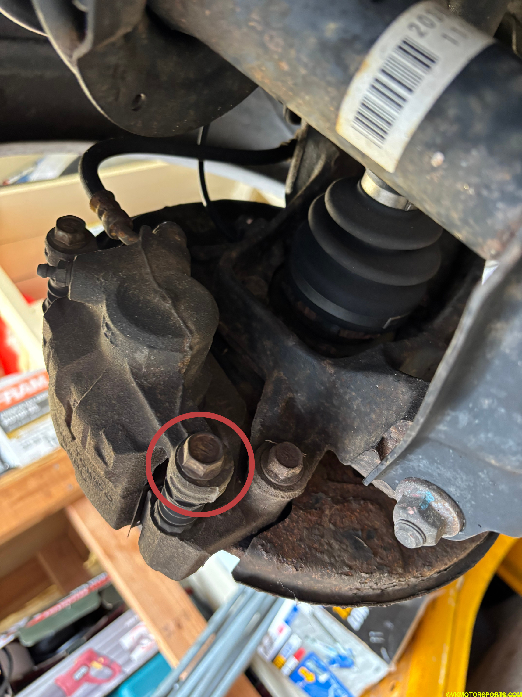Figure 13. Remove the caliper bolt circled in red